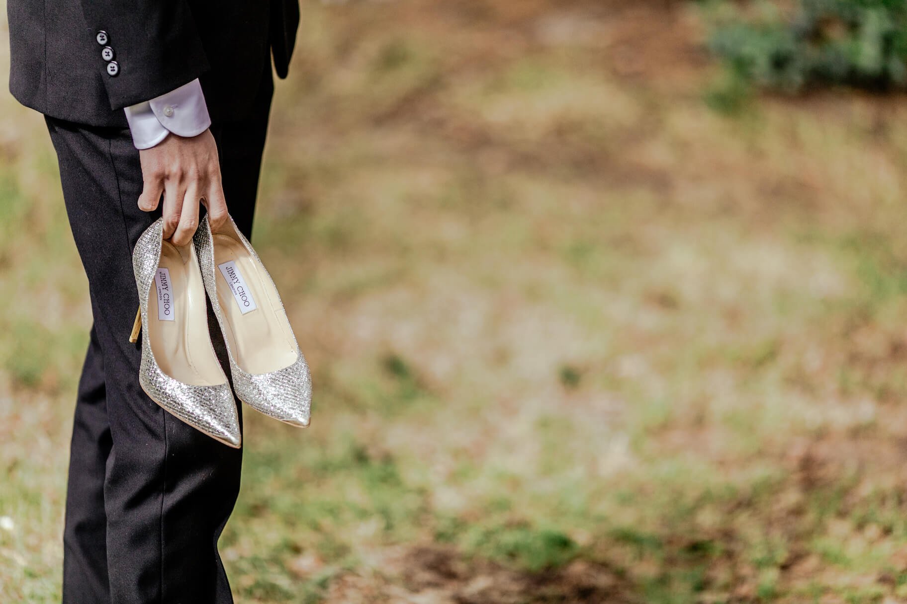 Groom holding wedding shoes — ready for the ceremony day
